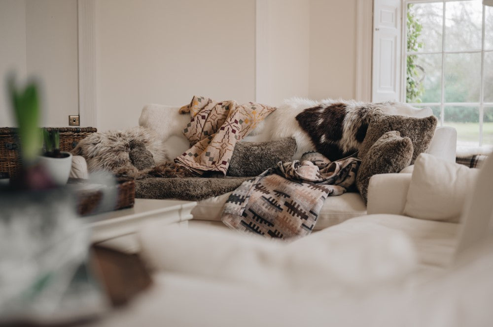 pile of sheepskin rugs, cushions and throws