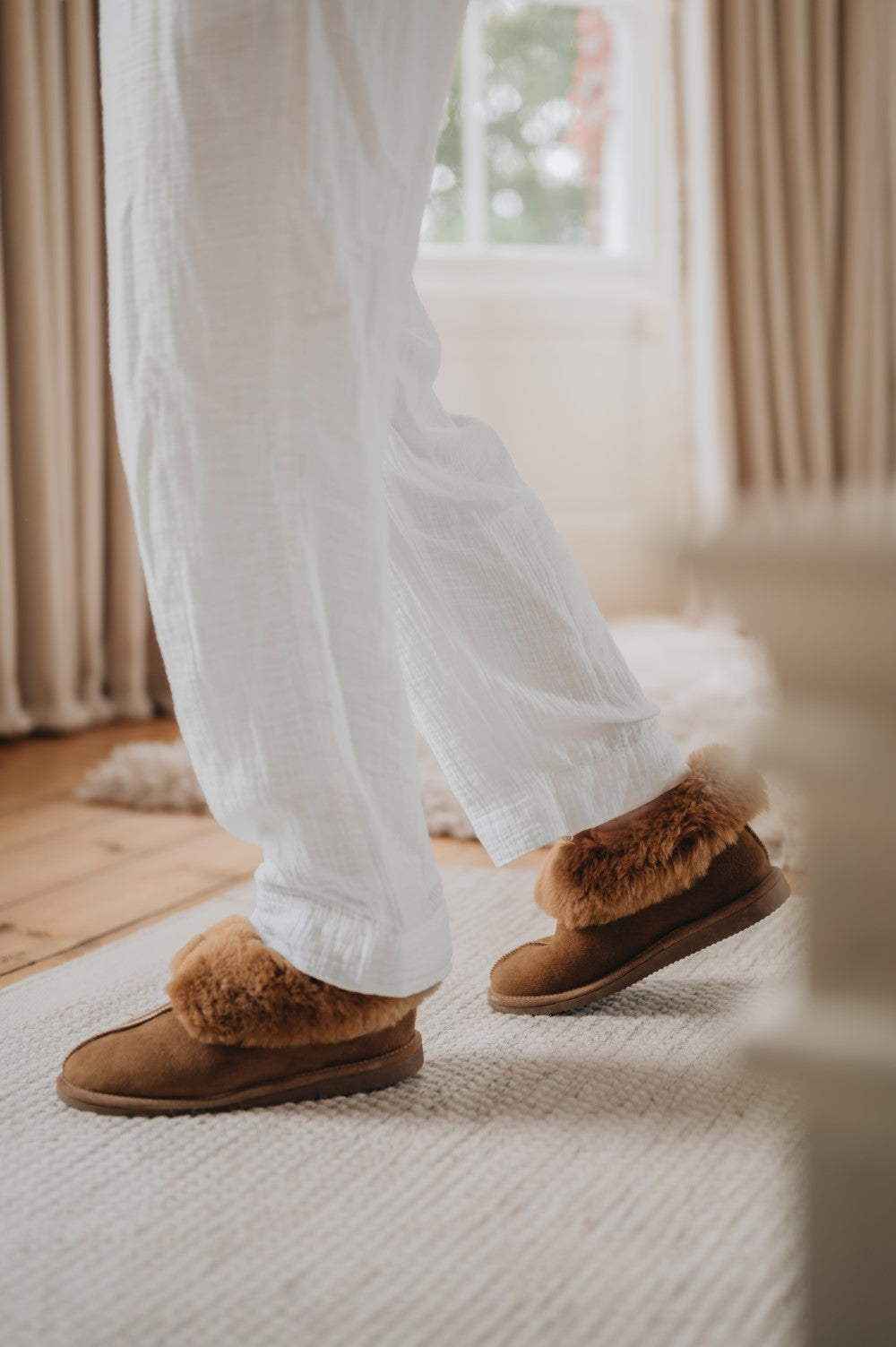 Womens Sheepskin Slippers walking across the carpet keeping feet warm