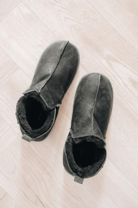 High-quality men's sheepskin slippers with durable soles, ideal for cold weather lounging.