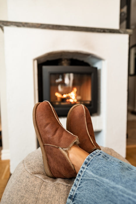 Genuine Sheepskin Slipper from Shepherd for men Anton Cognac in front of a warm fire