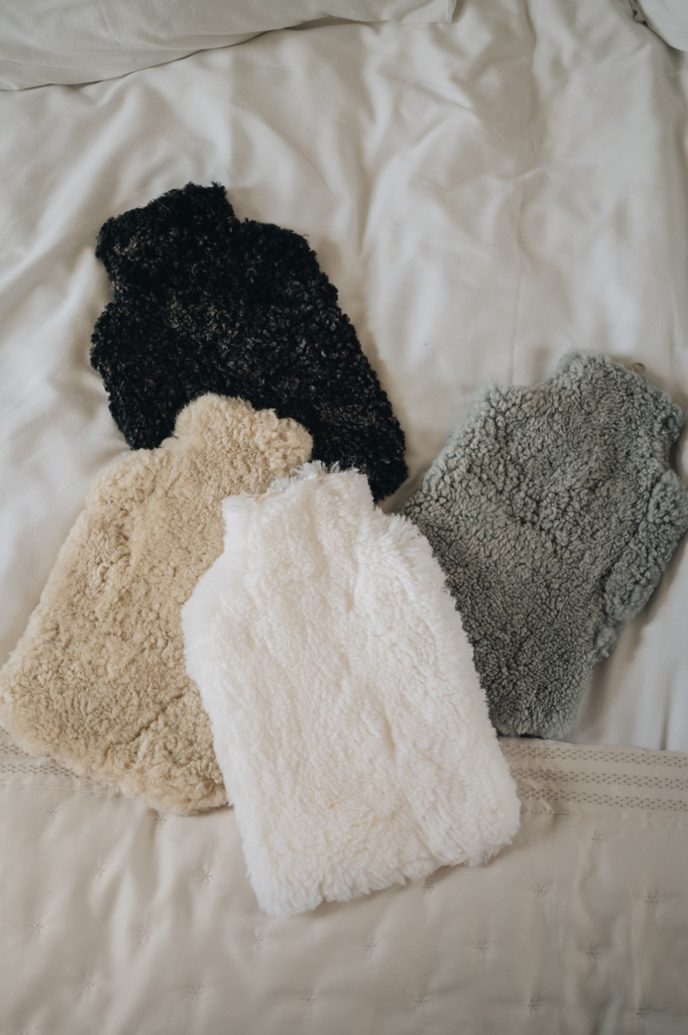 Margot slipper on bed with book and hot water bottle