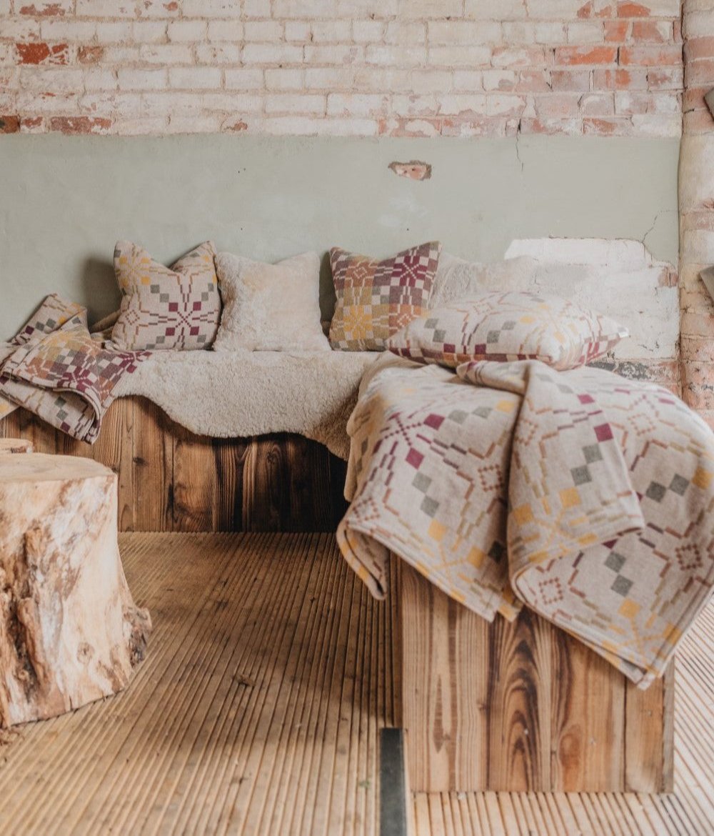 Sheepskin rug and cushions in oatmeal along side wool throws