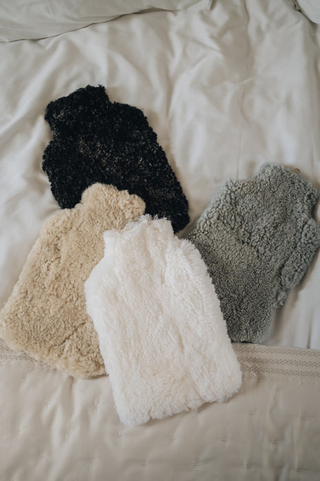 Luxury sheepskin hot water bottle cover in soft, fluffy wool for ultimate warmth and comfort, perfect for cosy nights and soothing aches.