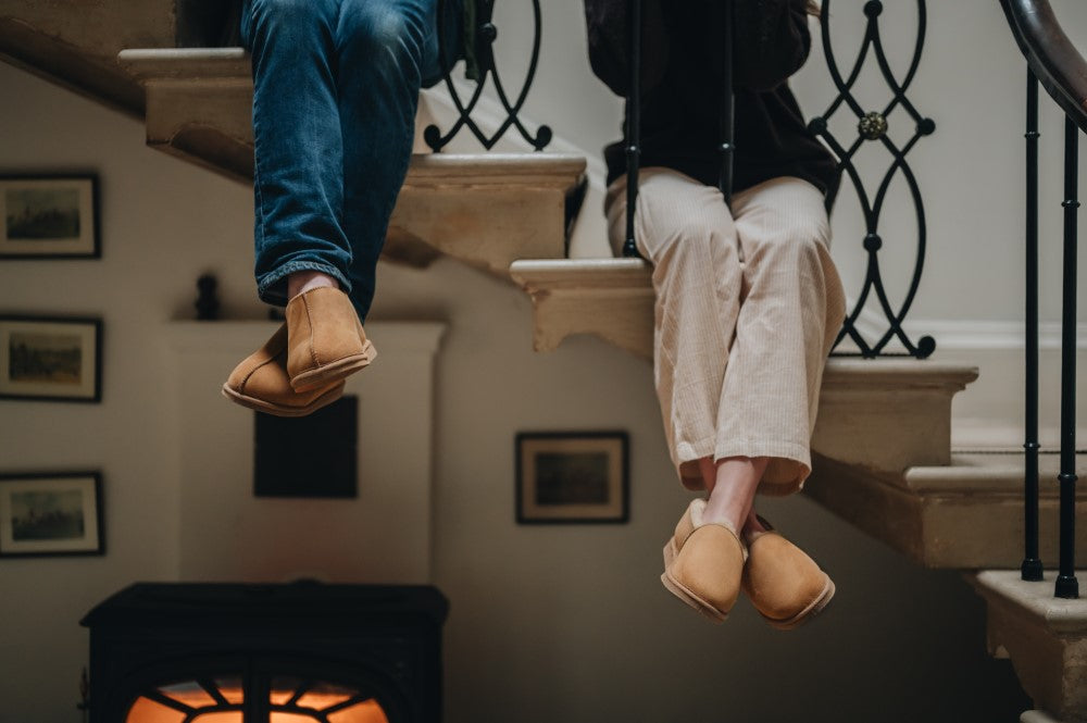 two sheepskin slippers hanging from railing