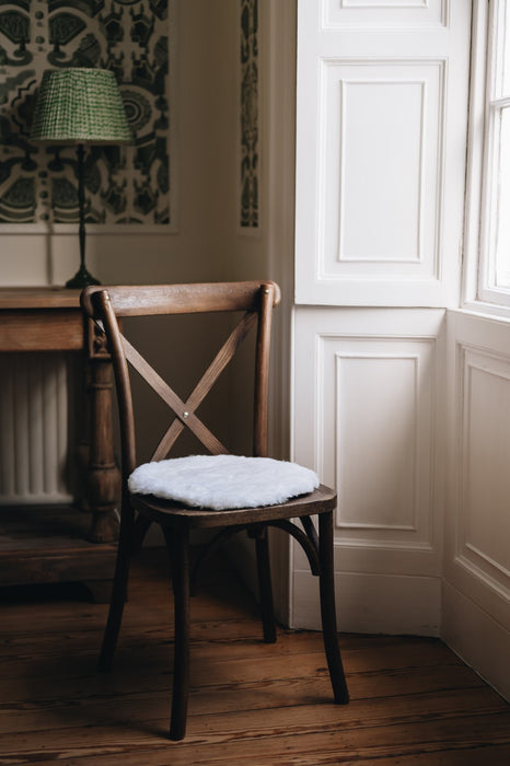 White rounded sheepskin seatpad on chair