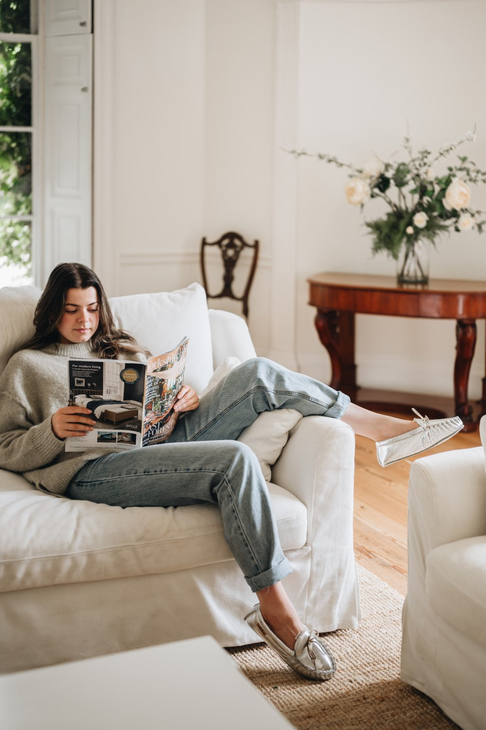 lady sat reading magazine wearing ava sheepskin slipper