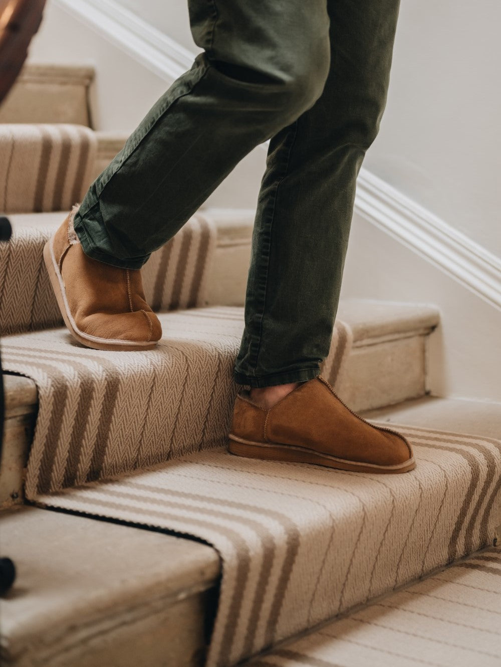 man walking down stairs in cadi sheepskin slipper